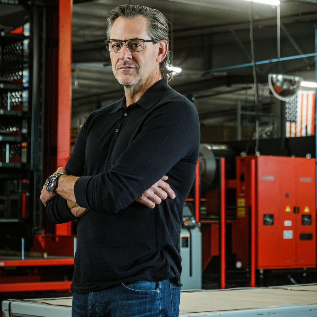 Michael Bailey standing in the warehouse with his arms folded