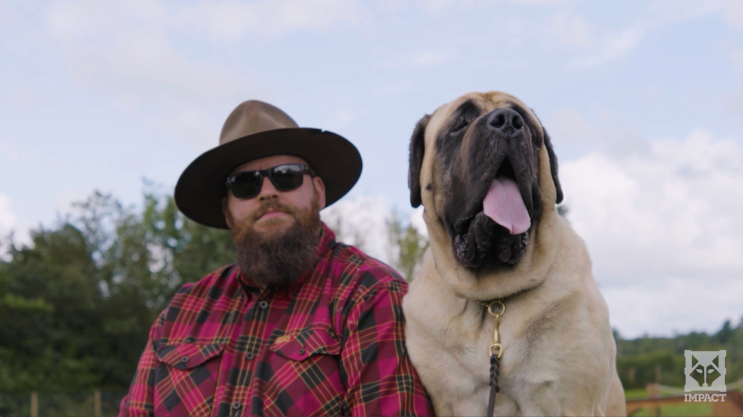 Will Atherton wearing a hat and sunglasses with a large dog outdoors